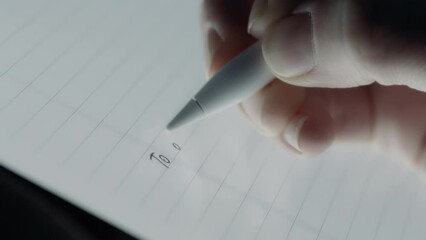 Person writing the to do list on a tablet using a pen. Slow motion.