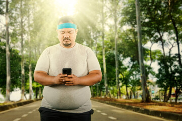 Man jogging in park while checking Smartphone