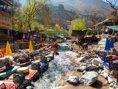 Riverside tables and eating spaces at colourful waterside restaurants in the Ourika Valley in the foothills of the Atlas Mountains in Morocco, North Africa. 