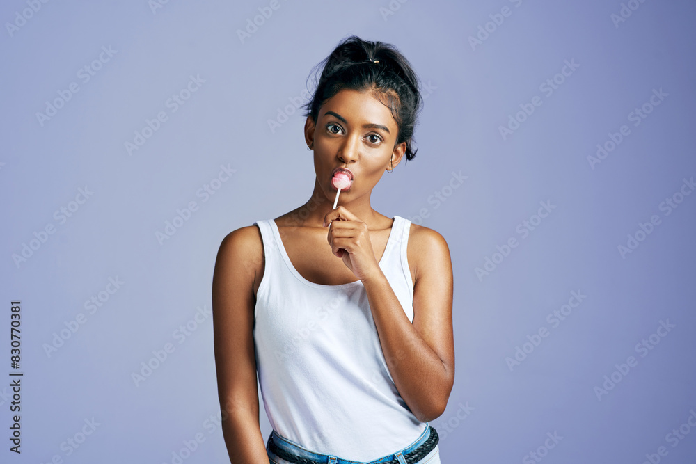 Sticker Woman, happy and eating lollipop in studio, summer and candy sweet for wellness with mock up space. Dessert, unhealthy snack and backdrop for treat, Indian female person and nutrition with model