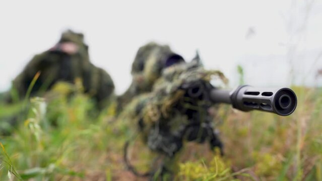 Close-up portrait of a military sniper in camouflage green army clothes. sniper in camouflage suit looking at the target. 4k video.