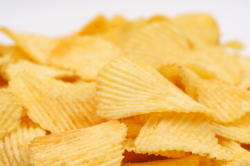 Crispy potato chips rotating in macro. Golden fried potatoes close up. Potato snack for unhealthy fast food.	
