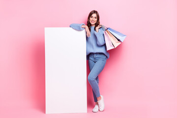 Full size photo of charming cheerful girl hold boutique bags huge empty space panel isolated on pink color background