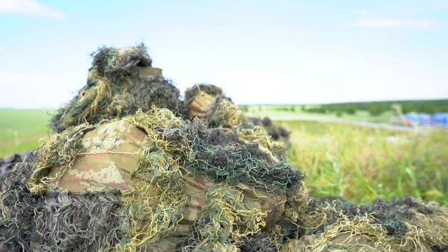 Close-up portrait of a military sniper in camouflage green army clothes. sniper in camouflage suit looking at the target. 4k video.