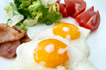 Healthy Breakfast: Sunny Side Up Eggs with Fresh Tomatoes, Greens, and Bacon - Perfect for Morning Meals and Nutrition Articles