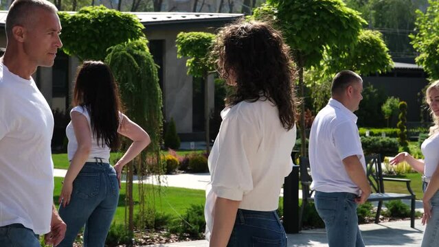 Staged dance Bachata a group of people dancing on the street the same movements White Shirts blue jeans adults and young people of different ages. Energy love life. Smooth sexy Latin dance moves
