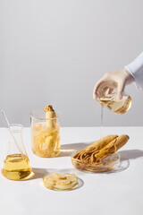 Some types of laboratory glassware contain ginseng root and ginseng essence displayed on white...