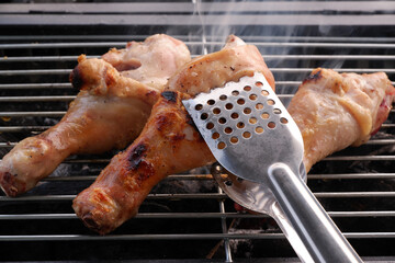 Close-up of grilling chicken legs on charcoal grill
