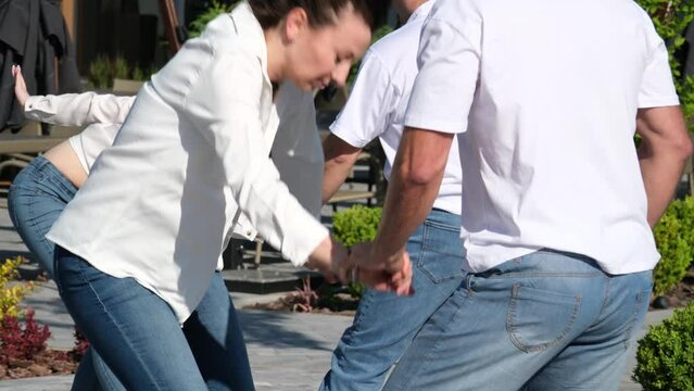 Staged dance Bachata a group of people dancing on the street the same movements White Shirts blue jeans adults and young people of different ages. Energy love life. Smooth sexy Latin dance moves