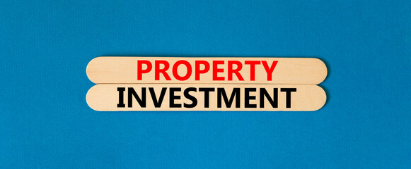 Property investment symbol. Concept words Property investment on beautiful wooden stick. Beautiful blue paper background. Business Property investment concept. Copy space.