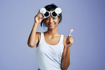 Girl, portrait and funny flower sunglasses as gen z on blue background for fashion, style and...