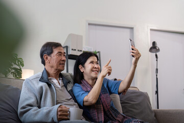 Senior couple taking selfie at home. Concept of technology, companionship, and relaxation