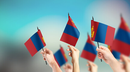 A group of people are holding small flags of Mongolia in their hands.