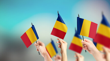 A group of people are holding small flags of Romania in their hands.