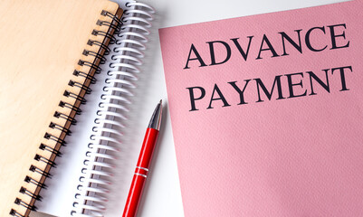 ADVANCE PAYMENT text on pink paper with notebooks