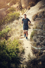 Obraz premium Man, hiking or travel with backpack running in nature for workout, sports and health on the mountain. Male person, fitness or exercise outdoor on adventure for cardio, training and journey alone