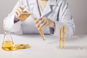 Frontal shot photo at scene a researcher holding a beaker of ginseng essence and pouring into a...