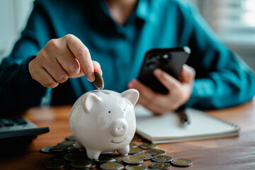 woman hand putting money coins into piggy bank for .planning saving money wealth to planning...