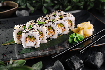 Elegant sushi roll platter on dark stone background