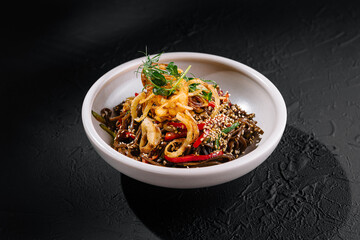Exotic spicy noodle dish on dark background