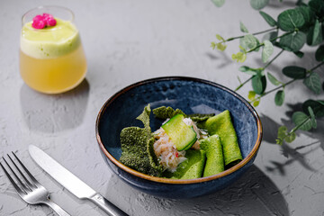 Gourmet green vegan crepes with spinach with crab meat and citrus drink