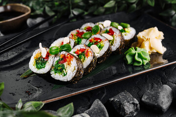 Gourmet sushi roll platter on dark slate