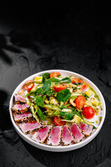 Gourmet tuna salad on dark background