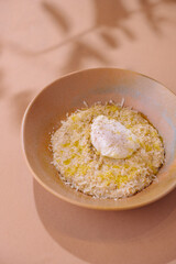 Creamy risotto with poached egg on pastel background