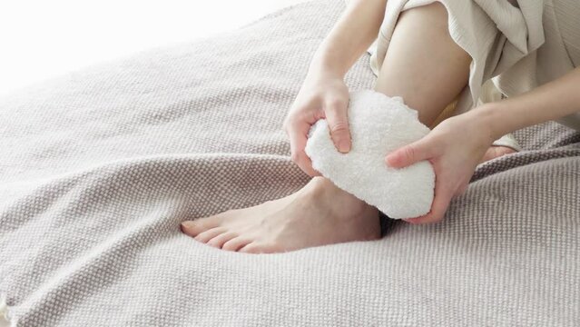 捻挫で痛めた足を冷やす女性