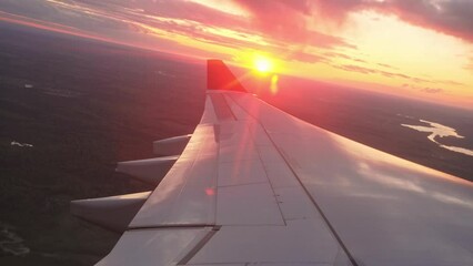 Passenger air plane fly high above sky. View from aircraft porthole. Comfortable fast airplane travel. Aviation concept. Airliner flight beautiful sunset. Fun summer journey. Wing of jet from window.