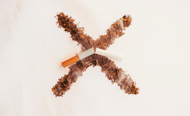 Tobacco cross on clear background and broken cigarette. Stop smoking. Cigarette, nicotine damages. World no tobacco day. Stop smoking message. Copy space