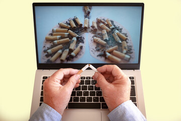 World No Tobacco Day. An adult Caucasian man looking at photos on the laptop of the negative...