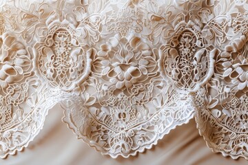 A lace fabric with a floral pattern is displayed on a bed