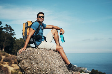 Man, outdoor and happy with backpack on rock with view for calm, relax and serenity on adventure...