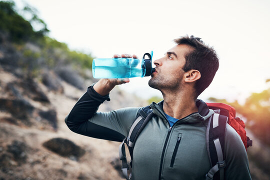 Hiking, fitness and man drinking water in nature with backpack for workout, training and adventure. Sports, liquid or thirsty athlete with refreshing drink in forest for trekking, challenge or travel - Powered by Adobe