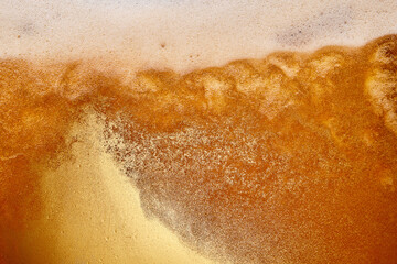 Naklejka premium Textured photo. Close-up of pouring foamy beer into glass. Light beer and has thick, creamy head of foam. Abstract background. Concept of refreshing alcohol drink, Oktoberfest, summer, party