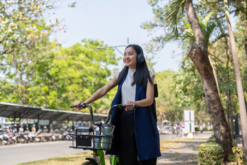 Businesswoman commuting to work by bicycle in urban park. Concept of eco friendly transportation, active lifestyle, and outdoor exercise