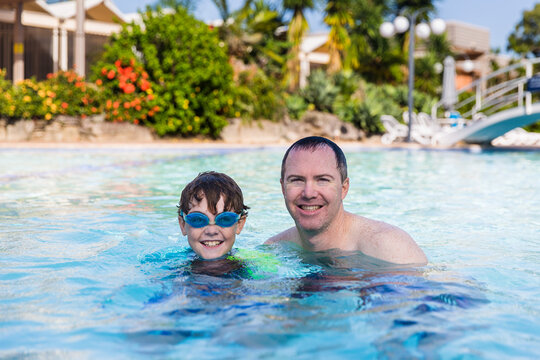 Father and son happy smiling in pool on holidays