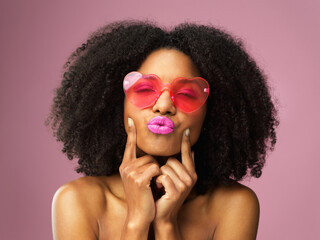 Studio, kiss and black girl with sunglasses, makeup and confident with cosmetics for face and...