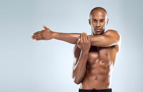 Black man, stretching and portrait in topless for skincare, wellness and health with fitness in studio. African, male person and pride with muscle for body, workout and results in white background