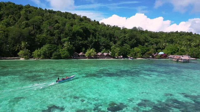Raja Ampat, Indonesia: Aerial drone footage of a boat bringing tourists in an homestay in the Kri island in the famous Raja Ampat archipelago in West Papua in Indonesia. 