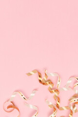 Golden ribbons on a pink background. Festive concept. Place for text.
