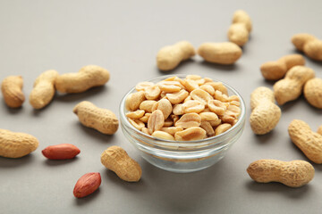 Roasted peanuts on bowl on grey background