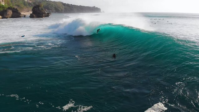 Drone view of surfing at barrel wave. Surfer riding on barrel wave. Swell in Bali