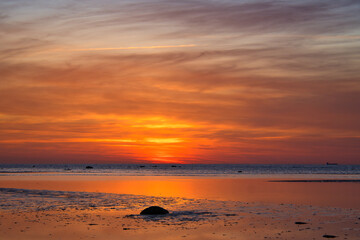 Obraz premium Sunset, illuminated sea. Sandy beach in the foreground. Light waves. Poel island
