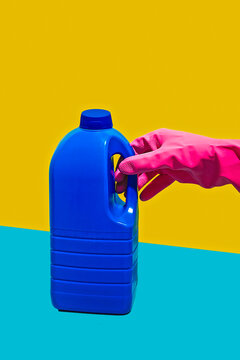 Hand with pink latex glove holding gallon