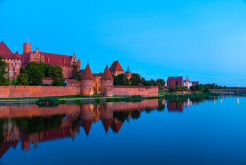 Obraz premium Marienburg castle the largest medieval brick castle in the world in the city of Malbork evening view at night