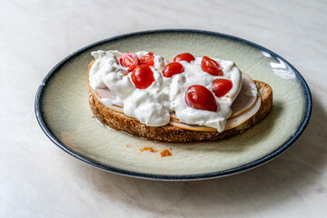 Delicious sandwich with burrata cheese, ham and cherry tomatoes.