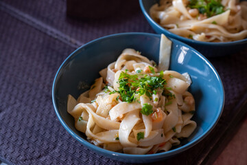 A bowl of freshly made pasta garnished with chopped herbs, capturing the vibrant and appetizing essence of a homemade meal