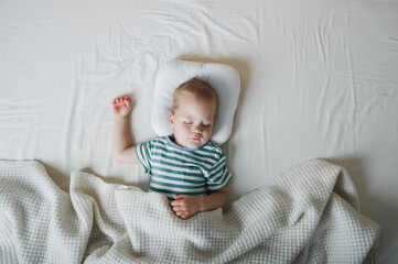Toddler boy sleeping close-up on bed. Health care concept